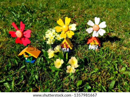 The cold time is over and the time of the warm days begins.
This picture shows nice pinwheels beside flowers in the grass.