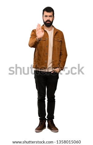 Handsome man with beard making stop gesture over isolated white background