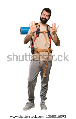 Hiker man counting nine with fingers over isolated white background