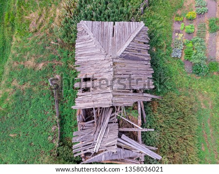 View of a ruined wooden house with a drone