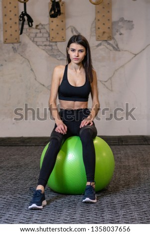 The girl is engaged on a fitness ball in the gym