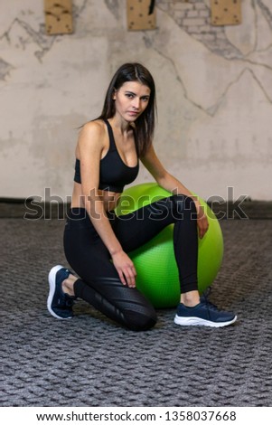 The girl is engaged on a fitness ball in the gym