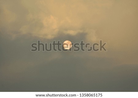 The sun behind the clouds.