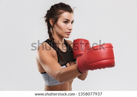 Picture of a beautiful young amazing strong sports fitness woman boxer posing isolated over white wall background make exercises with gloves.