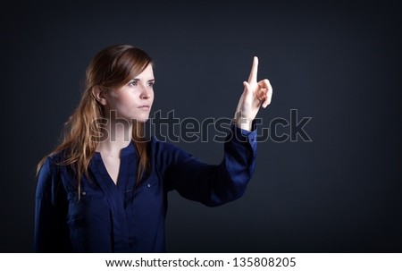 Woman's hand with finger on dark background