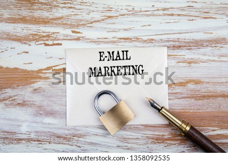 E-mail marketing concept. Paper letter, padlock and pen on a wooden table