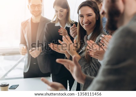 Great job! Successful business team is clapping their hands in modern workstation, celebrating the performance of new product Royalty-Free Stock Photo #1358111456