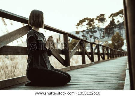 Girl meditating and practicing yoga in nature. Concept of exercise and relaxation