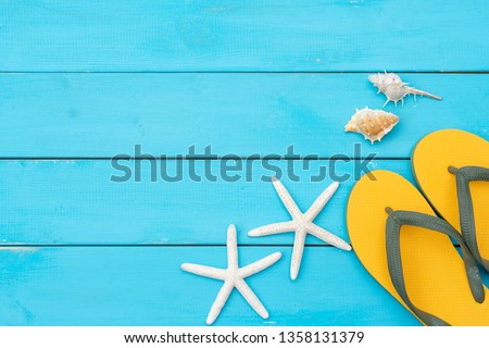 sandal and seashell on blue wooden rustic background. have a copy space for text.