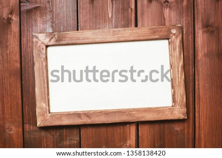 Empty copy space wooden photo frame. Hanging on wooden board wall. White blank frame design.