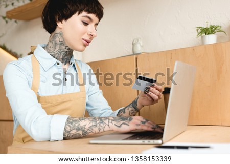 attractive waitress looking at credit card and writing in notebook