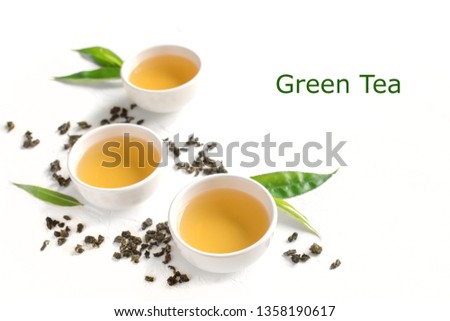Green tea in ceramic cups, dry green oolong tea and tea leaves isolated on white, copy space.