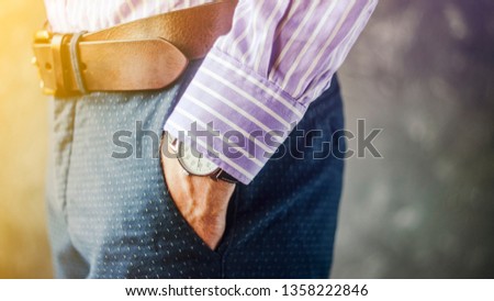 Close Up of Man Hand with Wrist Watch in the Pocket of Stylish Pants Close Up. Fashion Portrait of Businessman in Striped Shirt. Accessories for Men Style. Fashion and punctuality concept