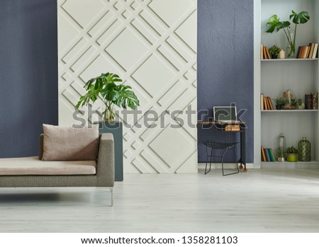 Home decoration interior room, dark blue stone wall background and decorative panel in the wall, grey bookshelf, sofa and coffee table in the room style.