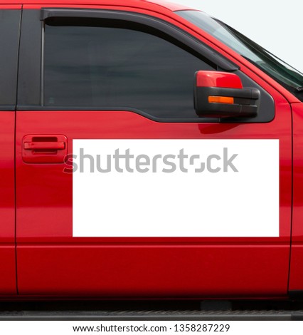 Vertical shot of a blank white magnetic sign on a red car’s passenger side door.