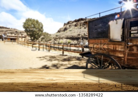 Wooden old table of free space for your decoration and Wild West background 