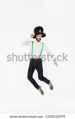 Full length of a cheerful young man celebrating St.Patrick 's Day isolated over white background, jumping