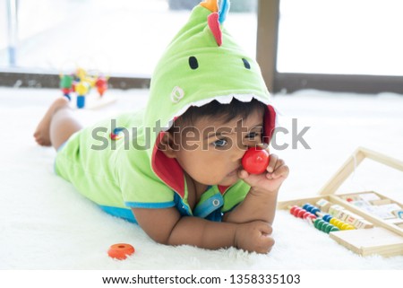 cute little asian baby boy lying and play toy