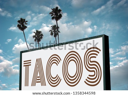 Aged and worn tacos sign with palm trees                              