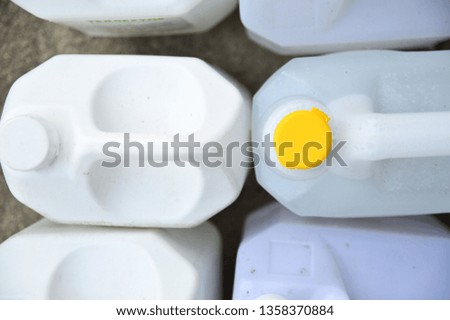 White fiber gallon with yellow and white lid.Packaging for filling oil, milk or chemicals.The image represents the device for storage various types of liquids.