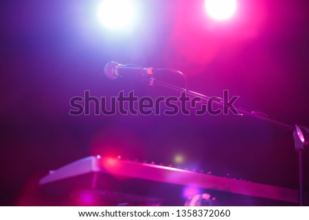 Microphone on stand on stage.Royalty free photos of professional vocal mic and digital synthesizer piano for musician.Curated collection with musical audio equipment