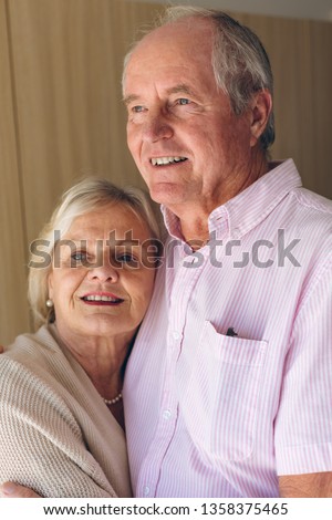 Close up of happy Caucasian senior couple posing while standing  at retirement home. Couple embrace each other