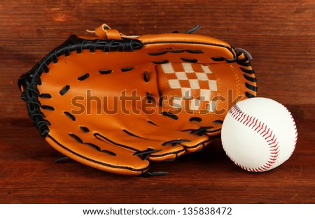 Baseball glove and ball on wooden background