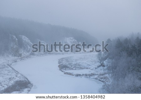 Beautiful view of the Iset river in the fog in winter with cliffs along the banks