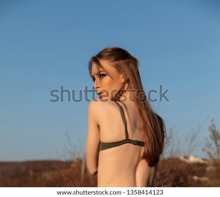 Fashion model portrait on the beach at sunset. Pretty girl in swimsuit. Beautiful bohemian styled woman.