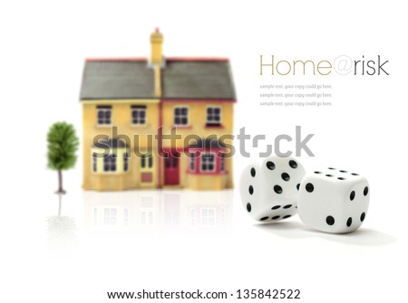 Investment risk concept stock photograph. Rolling dice and property against a white background. Copy space.