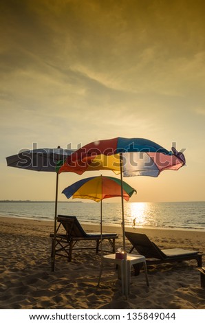 Silhouette umbrella at the beach and sunset