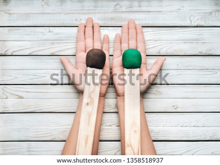 Two big matches in the hands of a girl on a wooden white background. Concept and photography. Creativity and copy space. Slight inflammation. Human choice.
