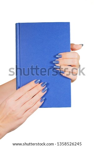 Closeup view of two female hands holding traditional paper book with blank blue cover isolated on white background. Vertical color photography.