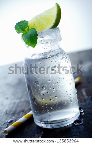 Ice jar on a wooden table with a wedge of lime and mint. Look at my portfolio for more cocktails.
