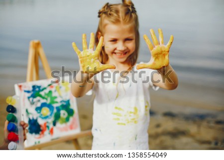 Little girl in a summer park. Cute child drawing near river