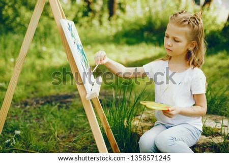 Little girl in a summer park. Cute child drawing