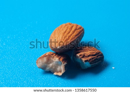 Almond close up macro on a blue background. Broken almonds for advertisement with salt clean and with shadows. Diet and food tasty