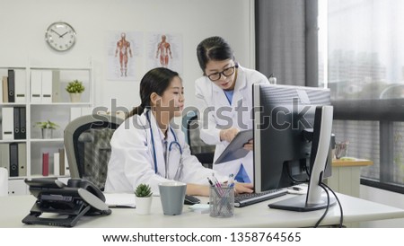 Portrait of two asian female doctors explaining tablet computer work to coworker. young girl using digital pad as working tool prescription of patient surgery talking to colleague in hospital office.