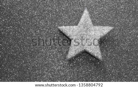 silver star on glitter material on grey shiny