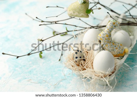 Easter scene with spring fresh greenery branches, rabbit and box of eggs, springtime festive background