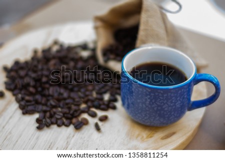 Black hot coffee in a blue cup on wooden tray, selective focused image of hot drink for morning refreshment during the break time of the meeting