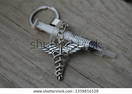 Medical Symbol. Pharmacy. Chrome caduceus over a wooden background 