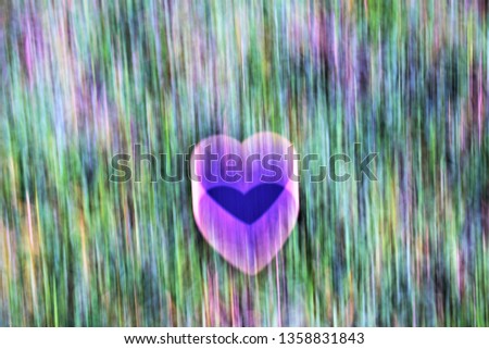 illustrated blurry blue heart on blurry green grass as background