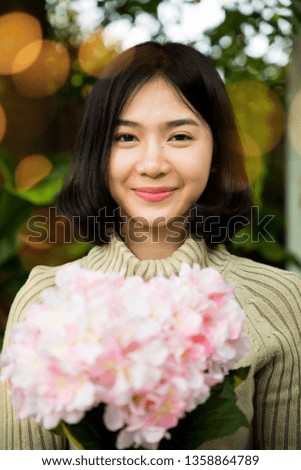 Portrait of a young beautiful women smelling and hold flowers