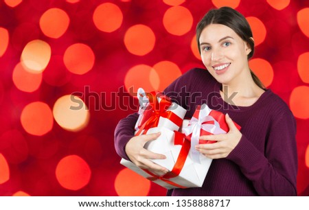 Happy pretty young woman holding gift box