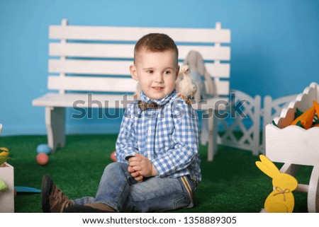 Cute boy rejoicing smiling with chipboard on shoulder at Easter photo shoot