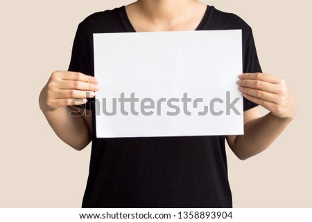 Young woman holding up copyspace Placard.Isolated on peach color background