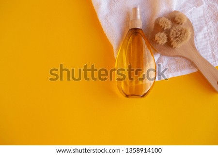 concept of body skin care, spa. towel, scrub brush, body oil on a yellow background