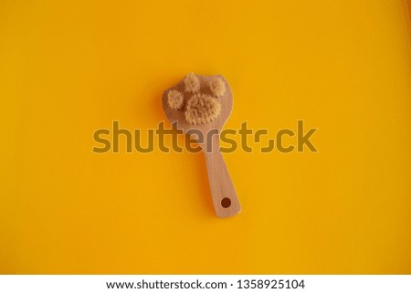 body skin care concept. scrubbing brush on a yellow background in the center
