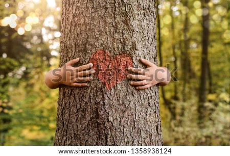 Nature lover, close up of child hands hugging tree with copy space Royalty-Free Stock Photo #1358938124